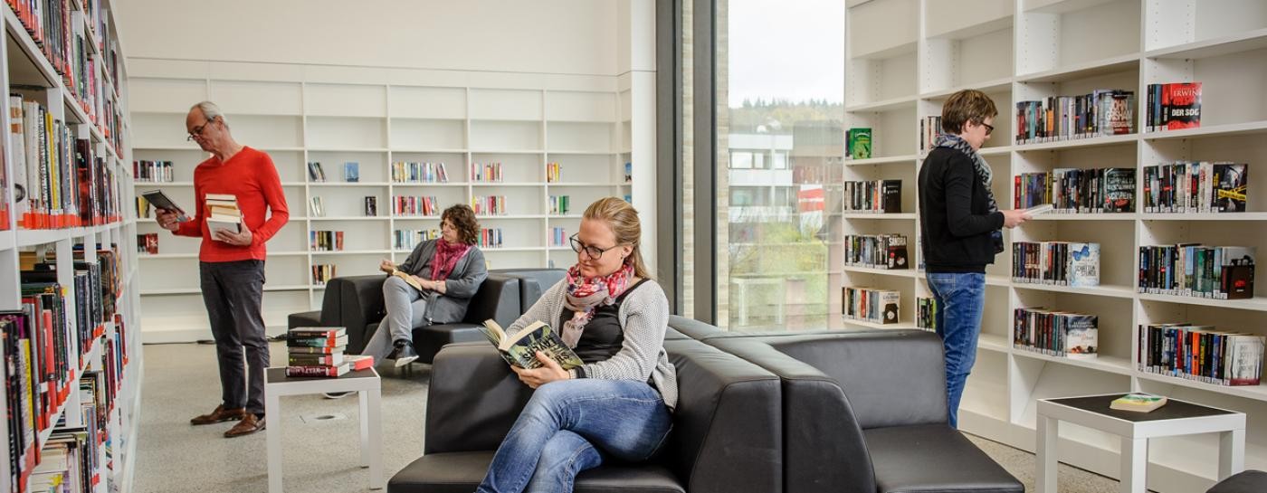 Menschen stehen in der Bibliothek Menschen stehen in der Bibliothek