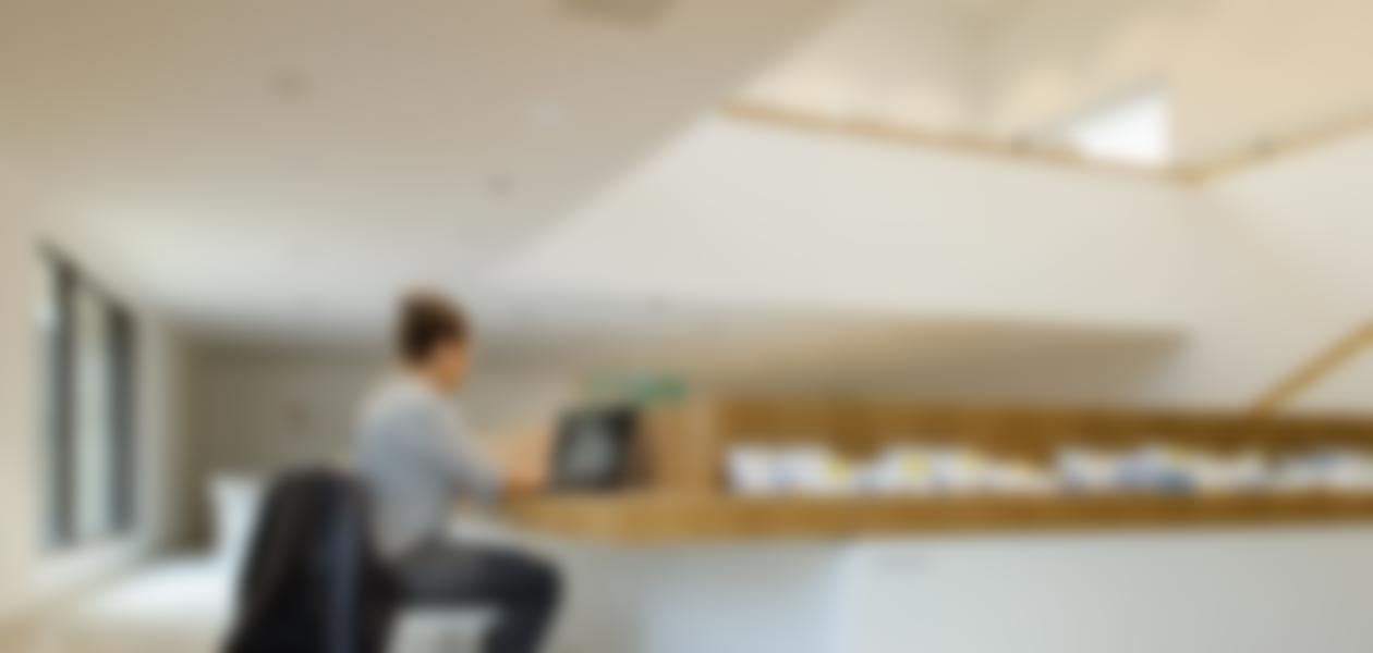 Mädchen sitzt vor Laptop in der Bibliothek